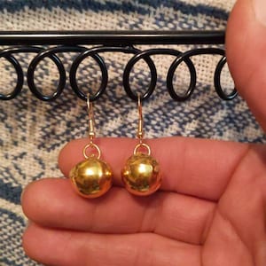 May include: A pair of gold dangle earrings with round ball charms.