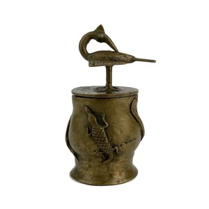 May include: A small, antique bronze box with a lid featuring a stylized fish design. The box is decorated with a lizard on the side.