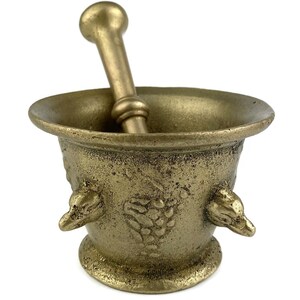 Peut inclure: Un mortier et un pilon dorés avec un motif de vigne et deux poignées en forme d'oiseau. Le mortier est en métal et a une surface texturée.