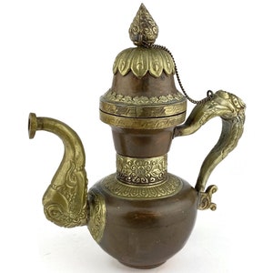 May include: A decorative brass and copper teapot with an ornate lid and a dragon-shaped handle.