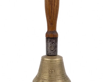 May include: A hand bell featuring a polished brass body with the number 12 embossed on the front, connected by a dark metal collar with a visible screw to a smooth, light brown wooden handle with a vertical grain pattern.