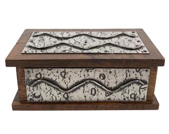 May include: A wooden box with a silver metal lid and base. The lid and base are decorated with a wavy pattern.
