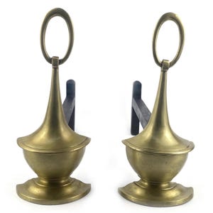 Peut inclure: Deux chenets de cheminée anciens en laiton et noirs. Chaque chenet présente un corps décoratif en forme d'urne en laiton avec une poignée et un support noir. Les chenets sont conçus pour maintenir les bûches dans une cheminée.