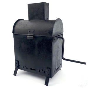 May include: A black metal antique roaster with a rectangular body, arched lid, and a chimney-like structure on top. It features a handle on the side and small legs. The roaster has a latch to secure the lid.