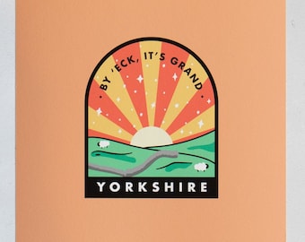 May include: A peach-colored card featuring a colorful Yorkshire design. The design includes a rising sun with orange and yellow rays, a green landscape with sheep, and the text "BY 'ECK, IT'S GRAND. YORKSHIRE."