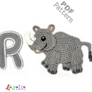 May include: A crocheted gray letter "R" and a gray rhino with a white horn and accents. The rhino has a smiling face and is next to the letter "R". The words "PDF pattern" are in the upper right corner. The word "Artist" is in the lower left corner.