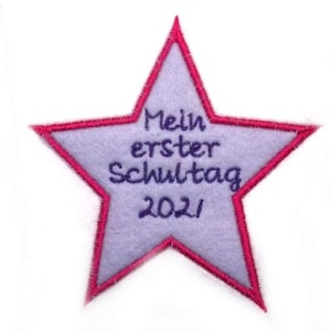 May include: A purple star-shaped patch with a pink border. The text "Mein erster Schultag 2021" is embroidered in purple on the patch.
