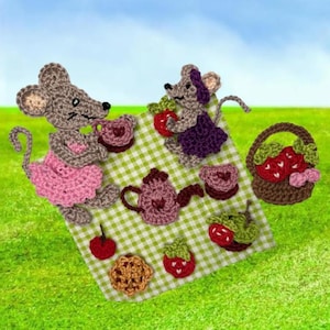 May include: Crocheted scene featuring two mice having a picnic on a green and white checkered blanket. The scene includes a teapot, teacups, strawberries, a basket of strawberries, and a cookie. The mice are wearing dresses.