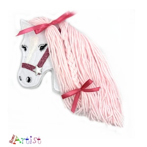 May include: White felt horse head with pink yarn mane and tail, decorated with pink glitter and red bows.