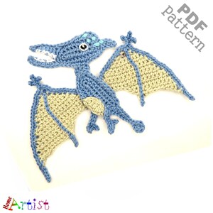 May include: Crochet pattern for a pterodactyl, a flying dinosaur with blue body and beige wings. The pattern is available as a PDF download.
