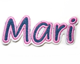 May include: A pink and blue embroidered iron-on patch with the name "Mari" in a cursive font.