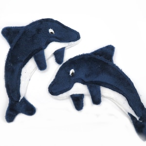 May include: Two plush dolphin toys in a playful arrangement. The dolphins are primarily navy blue with white bellies and accents. They have small, white eyes and are made of a soft, textured material. The toys are designed to resemble the shape of a dolphin.