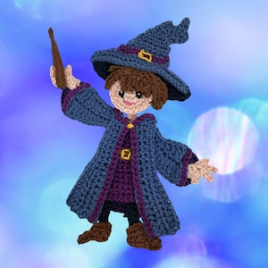 Pode incluir: Uma boneca de crochê de um mago vestindo um chapéu pontudo azul com uma fivela amarela, uma túnica azul com acabamento roxo e uma fivela amarela, e botas marrons. A figura tem cabelo castanho, pele clara e segura uma varinha marrom.