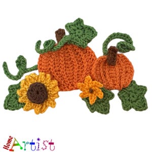 May include: A collection of crochet appliques featuring two orange pumpkins with brown stems, green leaves, and curling vines, accompanied by a large yellow sunflower with a brown center and a smaller orange flower with a brown center.