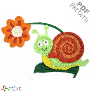 May include: Crochet pattern for a snail with a shell, a green body, and a flower. The snail is on a green leaf. The pattern is available as a PDF download.