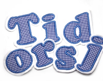 Könnte beinhalten: Blaue und weiße Gingham-Stoffbuchstaben, die das Wort "Tidors" buchstabieren.
