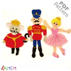 May include: Crochet pattern PDF for a Nutcracker, a mouse king, and a ballerina. The Nutcracker is wearing a red and gold uniform, the mouse king is wearing a red and gold robe, and the ballerina is wearing a pink tutu.