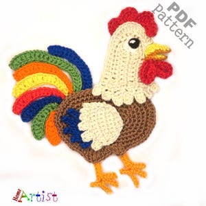 Könnte beinhalten: Gestickter Hahn-Applikation mit einem Regenbogen-Schwanz. Der Hahn ist braun, weiß und rot. Der Schwanz ist aus grünem, blauem, gelbem, orangefarbenem und rotem Garn gefertigt. Der Hahn steht auf einem weißen Hintergrund. PDF-Muster.