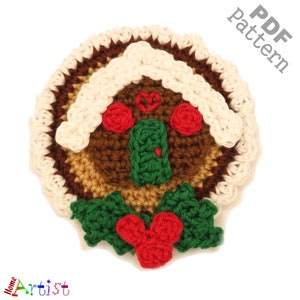 Op de afbeelding: Gehaakte gingerbread man-versiering met witte glazuur, rode snoepjes, groene hulstbladeren en rode bessen. PDF-patroon.