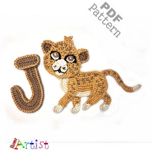 Op de afbeelding: Gebreide letter J in bruin en beige. Een gebreid leeuwenwelpje met bruin en beige bont staat naast de letter. De tekst "PDF pattern" staat in de rechterbovenhoek van de afbeelding.