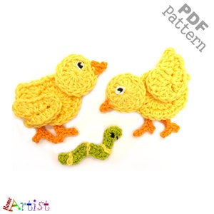 Puede incluir: Dos pollitos amarillos de crochet con patas naranjas y un gusano verde de crochet. Los pollitos están mirando al gusano. La imagen tiene el texto "PDF pattern" en la esquina superior derecha.