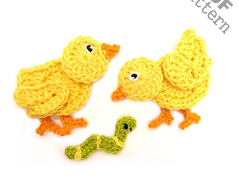 May include: Two yellow crocheted chicks with orange feet and a green crocheted worm. The chicks are looking at the worm. The image has the text "PDF pattern" in the top right corner.