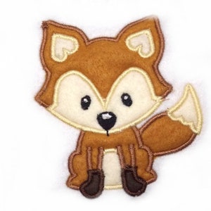 May include: A brown felt fox applique with a white face and black eyes. The fox is sitting with its tail curled behind it.