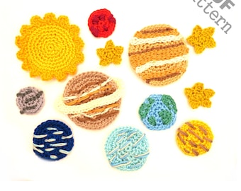 May include: A crochet pattern for a solar system, featuring a yellow sun, a red planet, a brown planet with white stripes, a blue planet with white stripes, a blue planet with green and white stripes, a yellow planet with brown stripes, a grey planet, and four yellow stars.