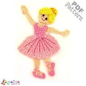 Può includere: Una bambola ballerina all'uncinetto realizzata con filato rosa e giallo. La bambola indossa un tutù rosa e un fiocco per capelli in filato giallo. La bambola è in una posa di danza con una gamba sollevata.