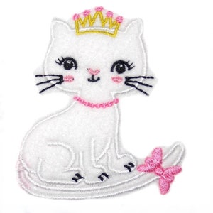 May include: White felt applique of a cat wearing a gold crown and a pink bow. The cat has black eyes and a pink nose.