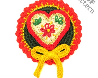 May include: Crocheted heart with a bow, in red, green, yellow, and white. The heart has a floral design. The heart is surrounded by a red and yellow crocheted circle. The text "PDF pattern" is in the upper right corner of the image.