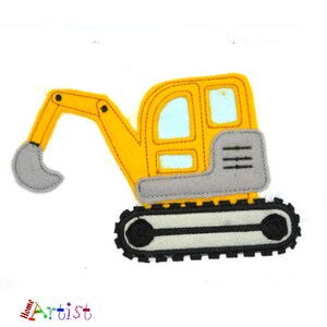 Puede incluir: Excavador de juguete de fieltro amarillo con una pala gris y orugas negras. El excavador tiene una cabina gris con una ventana amarilla.