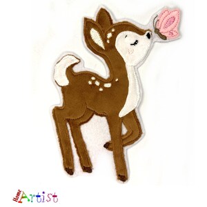 May include: An embroidered fawn in brown with white accents and a pink butterfly on a white background.