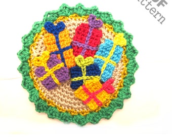 Può includere: Un ornamento natalizio all'uncinetto che presenta un cerchio di filato beige con un bordo verde e sei scatole regalo all'uncinetto colorate al centro. Il testo "PDF pattern" è scritto in nero su sfondo bianco nell'angolo in alto a destra dell'immagine.