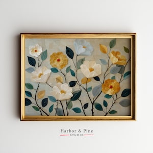 May include: A framed floral art print featuring white, yellow, and blue flowers with green and yellow leaves. The flowers have textured petals and are set against a light blue background. The frame is gold, and the print is labeled "Harbor & Pine STUDIO."