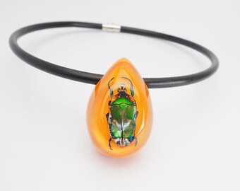 Fun egg shaped organge lucite necklace with real metallic beetle