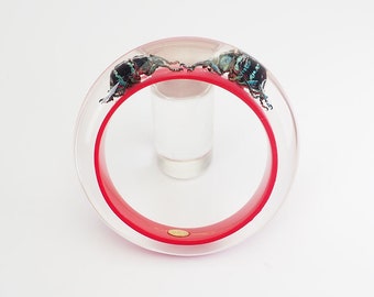 Red lucite bracelet with two blue beetles embedded