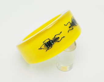 Bright yellow plastic lucite bracelet with two real blue insects