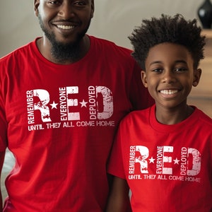 May include: Two people wearing red t-shirts with a white graphic that says "Remember Everyone Deployed Red Until They All Come Home".