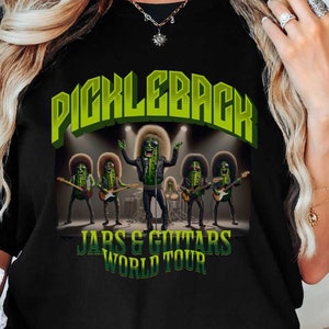 May include: Black t-shirt with a green and yellow graphic of a pickle band called "Pickleback" with the text "Jars & Guitars World Tour".