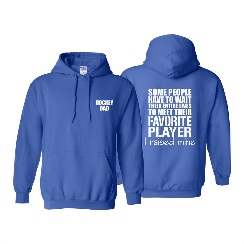May include: A royal blue hoodie with white text. The front of the hoodie says "Hockey Dad". The back of the hoodie says "Some people have to wait their entire lives to meet their favorite player. I raised mine."