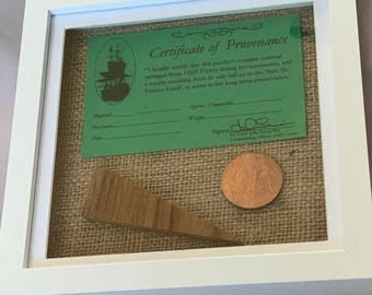 Copper rivet and oak taken from HMS Victory presented in a frame