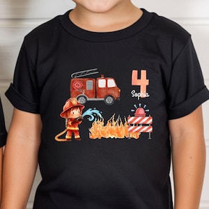 Könnte beinhalten: Zwei schwarze T-Shirts mit kurzen Ärmeln und einer Grafik eines roten Feuerwehrautos, eines Feuerwehrmanns, Flammen und einer roten Sirene. Ein Shirt zeigt die Zahl 3 und den Namen Alexander, das andere die Zahl 4 und den Namen Sophia.