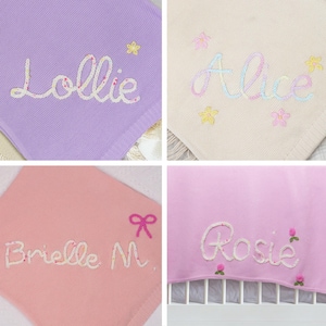 May include: Four personalized baby blankets with embroidered names. The blankets are in various colors, including purple, cream, pink, and light pink. Each blanket features a different name: Lollie, Alice, Brielle M., and Rosie.