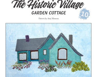 May include: A wool applique block featuring a teal and gray cottage with a chimney and windows, surrounded by embroidered flowers and greenery. The text "The Historic Village" and "Garden Cottage" are at the top, with the number "10".