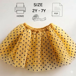 Puede incluir: Una falda de tul amarilla con un patrón de estrellas negras y cintura elástica. Sobre la falda, el texto indica SIZE 2Y - 7Y, HOME y PDF, junto a iconos de una impresora, una cinta métrica y un archivo de documento para imprimir.