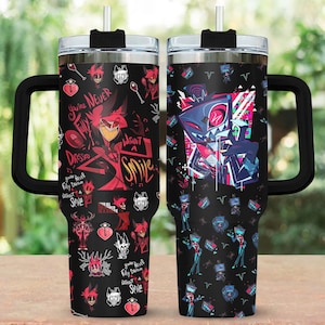 Puede incluir: Dos vasos térmicos negros con asas, con diseños de personajes de dibujos animados coloridos. Uno tiene gráficos rojos y negros con el texto "You're Never Fully Dressed Without a Smile". El otro tiene gráficos azules, rojos y rosas.