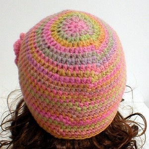 May include: A crocheted hat with a multi-colored design in shades of pink, green, and yellow.