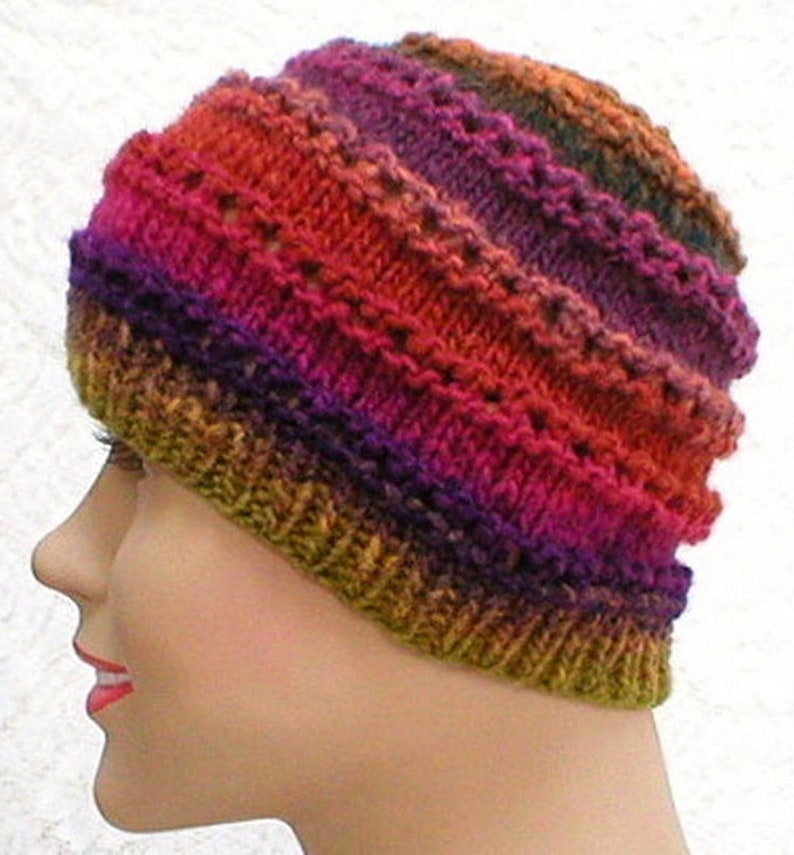 May include: A knitted hat with a multi-colored striped pattern in shades of orange, red, purple, and green.