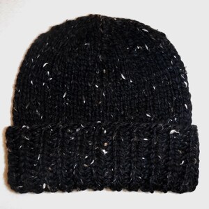 Puede incluir: Un gorro negro tejido con motas blancas. El gorro tiene un borde acanalado y un dise&ntilde;o cl&aacute;sico y ajustado. Este c&aacute;lido gorro de invierno es ideal para el clima fr&iacute;o.